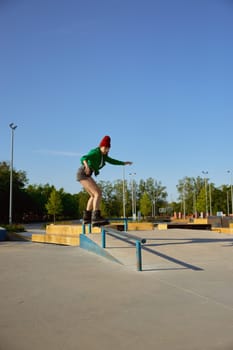Concentrated female inline-skater practicing stunts and tricks on special ramp in urban sports park