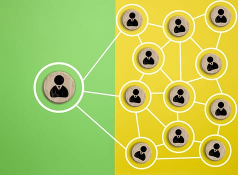 Wooden round block with staff icon which link connection network for organisation structure social network and teamwork concept, top view