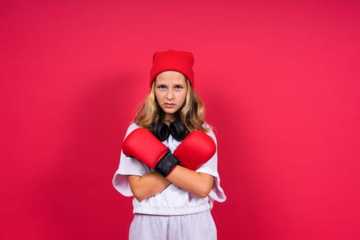 Cute little girl in boxing gloves on a red background studio