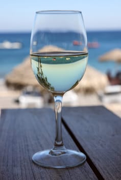 A glass of white wine at a restaurant by the beach in Kamari, Santorini. Greece