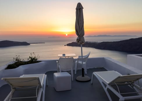 Terrace in the village of Imerovigli with amazing view of sunset over caldera in Santorini, Greece