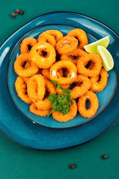 Deep fried calamari or squid rings on old wooden table.. Delicious fried food