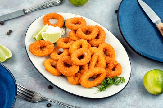 Deep fried calamari or squid rings on old wooden table.. Delicious fried food