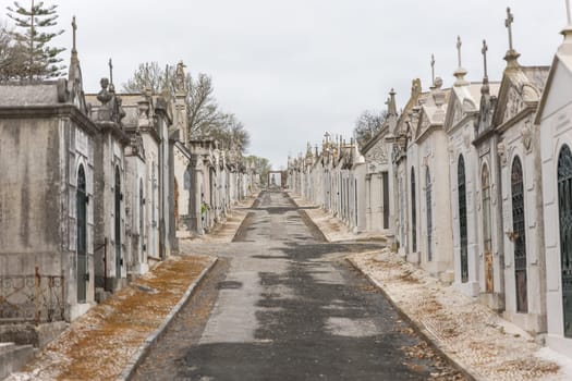 February 22, 2023 Lisbon, Portugal: Alto de Sao Joao Cemetery - a path leading forward surrounded by family crypts. Mid shot