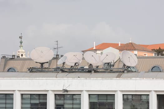 Satellite - TV plates on the roof of the building. Mid shot