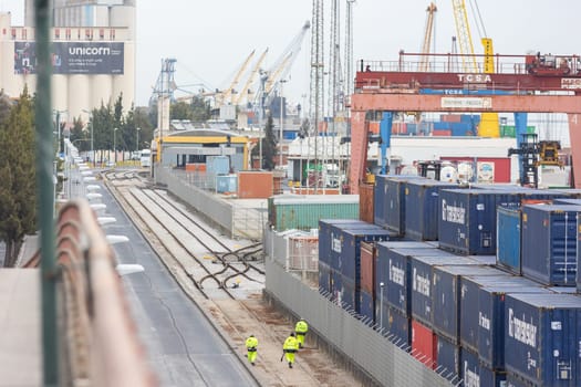 22 february 2023 Lisbon, Portugal: Terminal contentores de Santa Apolonia - several workers walking by the cargo port. Aerial view