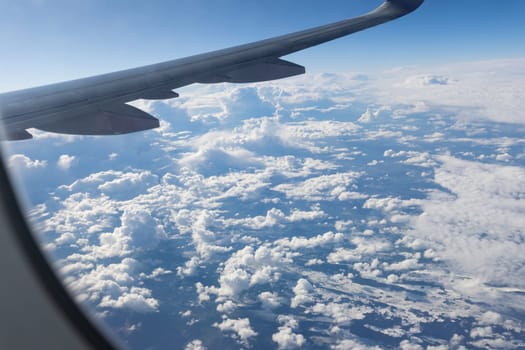 View of the clouds and the sky from the airplane window. POV