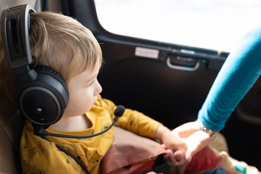 A little boy in helicopter wearing headphones. Mid shot