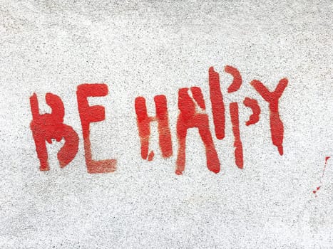 Be happy written in graffiti style with rough texture isolated on gray background.
