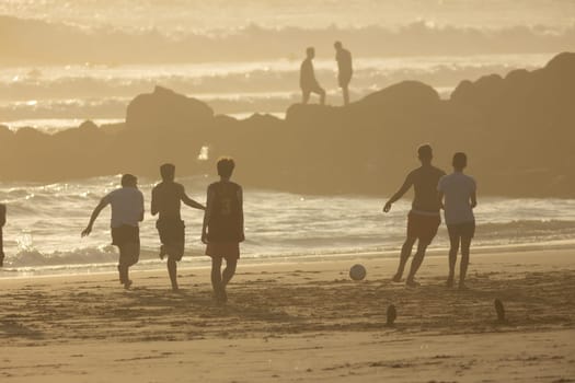 19 April 2023 Lisbon, Portugal: Costa da Caparica - young men playing with a ball on the beach. Mid shot