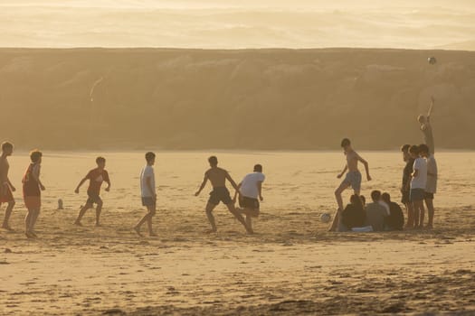 19 April 2023 Lisbon, Portugal: Costa da Caparica - young guys playing with a ball on the beach. Mid shot