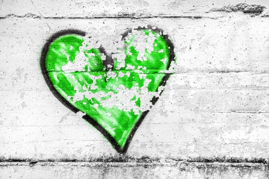 Painted green abstract heart shape love symbol, dirty wall background, metaphor to urban and romantic valentine, grunge style.