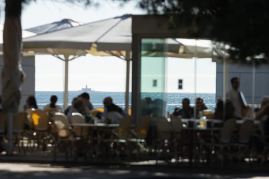 People in a summer cafe by the sea. Mid shot