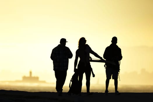 Black silhouettes of youth standing at sunset. Mid shot