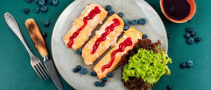 Baked salmon fish with blueberry berry sauce. Salmon fillets, grilled steaks on a wooden table. Top view.