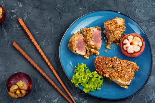 Steak of baked tuna in a nut with a mangosteens. Diet food. Flat lay.