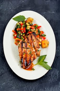 Grilled tuna steak served with vegetables salad on a plate