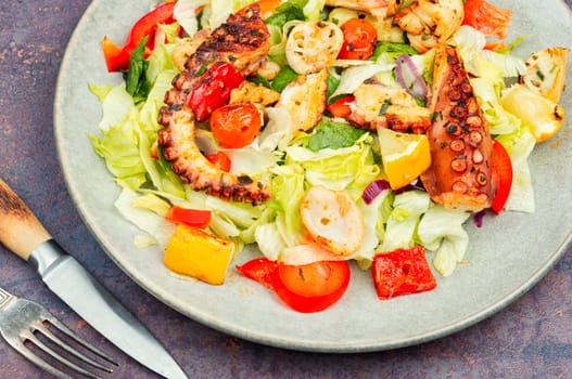 Tasty salad of fresh vegetables and octopus tentacles. Octopus salad. Copy space