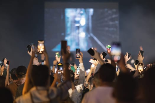 People shoot the concert on their phones. Mid shot