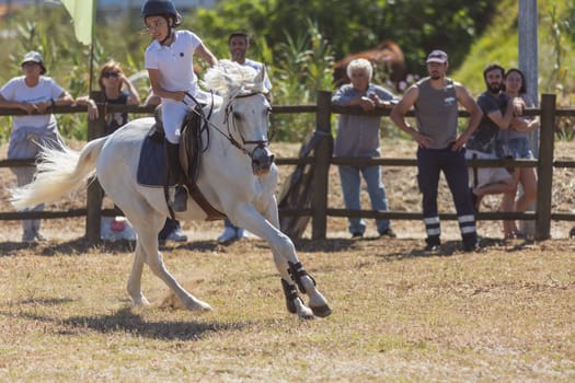 30 april 2023 Sobreda, Portugal: Festival Hipico da Sobreda - a girl riding a white horse at ranch. Mid shot