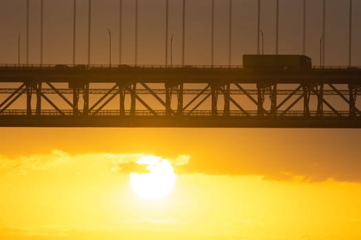 Bridge - Ponte 25 de Abril Lisbon Portugal - 25 april Bridge, cars and tracks moving over the bridge at sunrise or sunset, morning