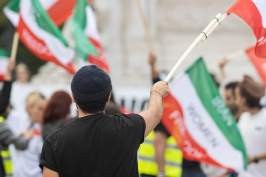 People waving flags at the rally dedicated to the incident in Iran. Mid shot