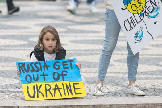 10-29-2022 LISBON, PORTUGAL: Ukrainian protest in Lisbon - little girl holds a poster in support of Ukraine. Mid shot