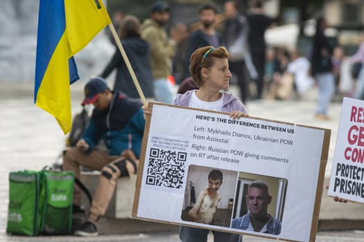 10-29-2022 LISBON, PORTUGAL: Ukrainian protest in Lisbon - a woman holds a poster with a QR code for donations to help rehabilitate the Ukrainian prisoners of war. Mid shot