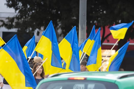 10-29-2022 LISBON, PORTUGAL: Ukrainian protest in Lisbon - people are holding lots of Ukrainian flags. Mid shot