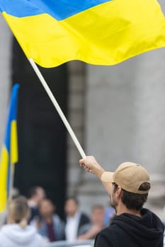 A man hold Ukrainian flag during protestA man hold Ukrainian flag during protest. Vertical shot
