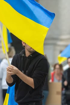 A bearded man hold Ukrainian flag during protest. Vertical shot