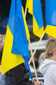 People hold Ukrainian flags during protest. Vertical shot