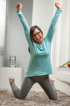 woman feeling successful for some winning reason in her house, precisely in her living room