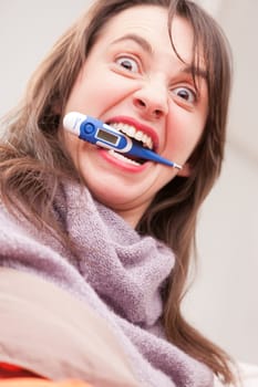 funny face on a concept of headache and illness of a young woman on a couch in her living room