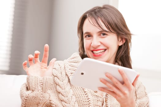 woman succesfully touching her tablet and smiling at camera