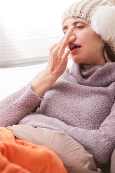 headache and illness of a young woman on a couch in her living room