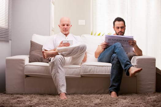 men reading on a sofa in a white living room in relax