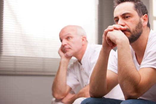 a couple of male friends thinking about something that worries them