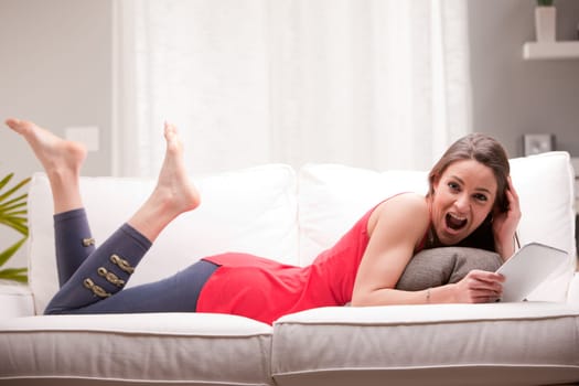 young woman surprised by something she is wieving on her tablet