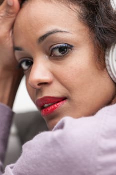 eye-catching portrait of an afroamerican woman listening music with headphones and turning to the camera