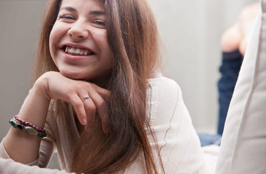 girl smiling or laughing on her sofa in her living room