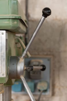detail of a boring machine in a carpenter workshop with a very shallow depth of field