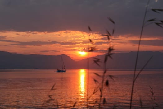 Scenic sunset and a lonely sailboat at the coast of Trogir, Croatia