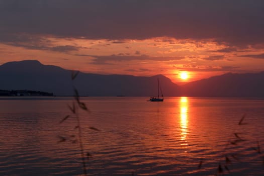 Scenic sunset and a lonely sailboat at the coast of Trogir, Croatia