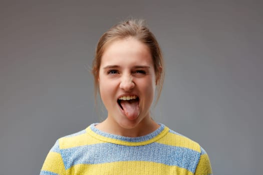 bleahh! portrait of young woman with tongue out! she is incorrigibly mischievous, but she makes herself forgiven