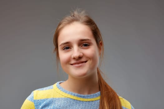 young beautiful woman in yellow striped sweater smiles adorably because she is satisfied