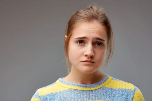 How sad! Young woman with expression of sadness and disappointment. Portrait of sad girl, frontal.