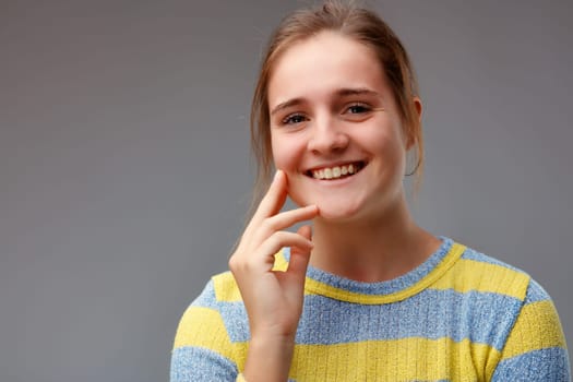 Young woman with such an open smile that she is about to laugh. It shares a feeling of joy and fun.