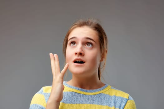 Emphatic and theatrical gesture of a young woman who had a revelation, perhaps an idea. But she may also have forgotten the gas on.
