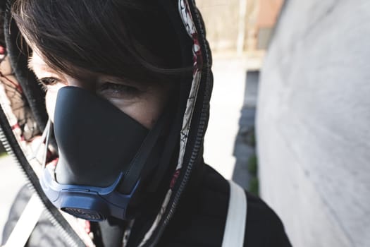 woman with a gas mask walking on the city streets surviving a corona virus pandemic or post atomic world